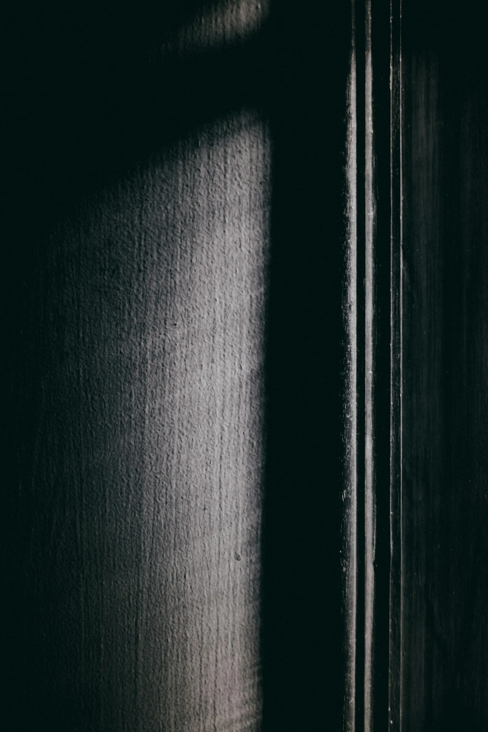 Faisceau de lumière sur un mur texturé, ambiance sobre